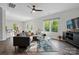Comfortable living room with a cozy sectional sofa, modern decor, and natural light from large windows at 11040 E Lake Rd, Charlotte, NC 28215