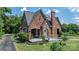 Charming brick home with unique architecture, lush landscaping, and a welcoming front porch at 115 12Th Sw St, Hickory, NC 28602
