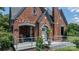 Close-up of brick home's front porch with seating and flowers creating a warm entrance at 115 12Th Sw St, Hickory, NC 28602