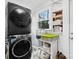 Laundry room features a black stackable washer and dryer set, storage shelving, and a window at 115 12Th Sw St, Hickory, NC 28602