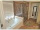 Modern bathroom featuring a glass-enclosed shower and a soaking tub with tile surround at 119 W Maranta Rd, Mooresville, NC 28117