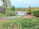 Lakefront view features a serene beach area, a covered dock with kayaks, and lush greenery at 119 W Maranta Rd, Mooresville, NC 28117