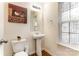 This is a half bathroom with a pedestal sink, toilet, and stained glass window at 1213 Salvadore Ct, Gastonia, NC 28052
