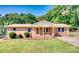 Charming brick ranch home with a well-maintained lawn, front porch, and mature trees at 124 Riley Rd, Dallas, NC 28034