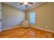 Neutral bedroom with wood floors and a natural-colored upholstered armchair at 133 Misty Woods Dr, Lake Wylie, SC 29710