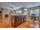 This kitchen island and dining area have hardwood flooring, granite counters and stainless appliances at 133 Misty Woods Dr, Lake Wylie, SC 29710