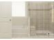 Clean bathroom with a combined tub and shower, featuring neutral tile, and an open door at 1552 Croydon St, Indian Land, SC 29707