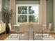 Modern dining room with a round white table, woven chairs, a large window, and stylish accents at 1552 Croydon St, Indian Land, SC 29707