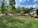Backyard of a home with a flag, waterfall, bench, outbuildings, and a manicured lawn at 179 Tomahawk Ln, Mount Gilead, NC 27371