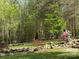A backyard with a waterfall, statue, flag, bench, and mature trees at 179 Tomahawk Ln, Mount Gilead, NC 27371