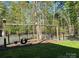 A swing set is anchored in the grass backyard with a partial black fence, and mature trees at 179 Tomahawk Ln, Mount Gilead, NC 27371