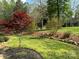 A backyard has a red maple tree, a seating area, and a decorative stacked stone border at 179 Tomahawk Ln, Mount Gilead, NC 27371