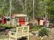 A backyard shows an outbuilding with a pergola, bench, statue, and an American flag at 179 Tomahawk Ln, Mount Gilead, NC 27371