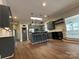 Open kitchen design with stainless steel appliances, center island, and hardwood floors, seamlessly connecting living spaces at 179 Tomahawk Ln, Mount Gilead, NC 27371