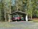 Trailer and boat parked beneath a metal outbuilding amid a wooded landscape at 179 Tomahawk Ln, Mount Gilead, NC 27371
