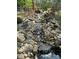 Backyard water feature shows a rock waterfall cascading down into a pool of water at 179 Tomahawk Ln, Mount Gilead, NC 27371