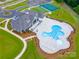 Aerial view of a clubhouse with a pool, tennis courts, and lush greenery at 2037 Mantle Ridge Dr, Indian Trail, NC 28079