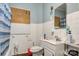 Compact bathroom featuring a vanity sink, toilet, white tile walls, and blue painted accent wall at 21 W D St, Newton, NC 28658