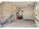 Spacious garage with unfinished walls, painted floor, stairs to storage, and natural light from a window at 21 W D St, Newton, NC 28658