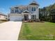 Stylish two-story house boasts a large driveway, manicured lawn, and inviting curb appeal under a bright, sunny sky at 2108 Sabra St, Gastonia, NC 28054