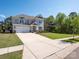 Charming two-story home features a spacious driveway and well-manicured lawn, surrounded by lush trees and clear blue skies at 2108 Sabra St, Gastonia, NC 28054