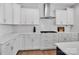 Modern kitchen with white cabinets, stainless steel range hood, and tile backsplash at 2108 Sabra St, Gastonia, NC 28054