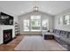 Cozy living room with fireplace, large windows, and comfortable sectional sofa at 2108 Sabra St, Gastonia, NC 28054
