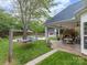 A spacious backyard features a stone patio with an outdoor fireplace and a hammock near a pool at 212 Horn Tassel Ct, Indian Trail, NC 28079