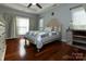 Bright bedroom with hardwood floors, tray ceiling, a ceiling fan, and two windows for natural light at 212 Horn Tassel Ct, Indian Trail, NC 28079