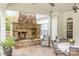 Covered patio with stone fireplace, ceiling fans, and comfortable seating area at 212 Horn Tassel Ct, Indian Trail, NC 28079