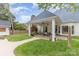 Spacious backyard featuring an outdoor fireplace, covered patio with ceiling fans and a grassy area at 212 Horn Tassel Ct, Indian Trail, NC 28079