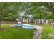 Backyard pool surrounded by trees, grass, and a shed at 212 Horn Tassel Ct, Indian Trail, NC 28079