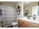Well-maintained bathroom with a classic vanity, decorative mirror, and patterned shower curtain at 227 Donsdale Dr, Statesville, NC 28625