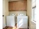 Functional laundry room with washer, dryer, and upper cabinets at 227 Donsdale Dr, Statesville, NC 28625