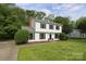 Beautifully landscaped two-story home with black shutters, well maintained lawn, and large shade trees at 2413 Bergen Ct, Charlotte, NC 28210