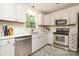 Bright kitchen features white cabinets, stainless steel appliances, and a farmhouse sink at 2413 Bergen Ct, Charlotte, NC 28210