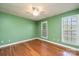 A green bedroom boasts hardwood floors, a ceiling fan, and natural light from the window at 2426 36Th Ne Ave, Hickory, NC 28601
