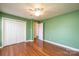 A green bedroom featuring hardwood floors, a ceiling fan, and double door closet at 2426 36Th Ne Ave, Hickory, NC 28601
