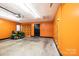Bright garage with orange walls, a lawn mower, and a garage door at 2426 36Th Ne Ave, Hickory, NC 28601