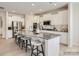 Open-concept kitchen featuring white cabinets, stainless steel appliances, a large island, and barstool seating at 2803 Morning Song Way, Lancaster, SC 29720