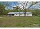 Backyard view of the home featuring white siding, a screened-in porch, and a large shade tree at 2825 Old Pageland Marshville Rd, Wingate, NC 28174