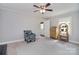 Bright living room features neutral walls, ceiling fan, patterned accent chair, and natural light from a window at 2825 Old Pageland Marshville Rd, Wingate, NC 28174