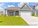 Charming single-Gathering home with green siding, a two-car garage, and a well-manicured front lawn at 36131 Greg Norman Dr # 1031, Lancaster, SC 29720