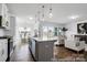Open-concept kitchen with island, bar seating, stainless steel appliances, and a view into the living room at 36131 Greg Norman Dr # 1031, Lancaster, SC 29720