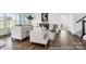 Open-concept living room featuring hardwood floors, comfortable seating, and abundant natural light from many windows at 36131 Greg Norman Dr # 1031, Lancaster, SC 29720