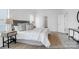 Spacious main bedroom with plush gray bedding, side tables, and a view into the home's entrance and closet at 36131 Greg Norman Dr # 1031, Lancaster, SC 29720