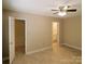 Bedroom featuring tan walls, tile floors, ceiling fan, and bathroom access at 380 Sweetgum Dr, Fort Mill, SC 29715