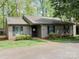 Charming single-story home with mature trees, green lawn, and cozy, inviting entrance at 380 Sweetgum Dr, Fort Mill, SC 29715
