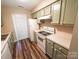 Compact kitchen with light green cabinets and modern appliances maximizes space and functionality at 380 Sweetgum Dr, Fort Mill, SC 29715