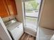 A laundry room with white washer and dryer, cabinets, and natural light through the window at 380 Sweetgum Dr, Fort Mill, SC 29715